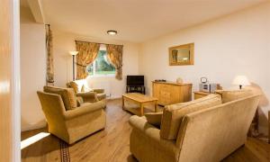a living room with chairs and a couch and a table at Troutbeck - Whitbarrow Village in Penrith