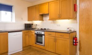 a kitchen with wooden cabinets and a stove top oven at Troutbeck - Whitbarrow Village in Penrith