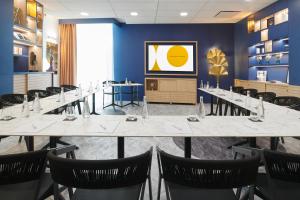 Seven Urban Suites Nantes Centre في نانت: غرفة طعام كبيرة مع طاولة وكراسي طويلة