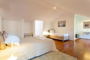 - une chambre blanche avec 2 lits et une lampe dans l'établissement Correeiros downtown Duplex & Deluxe Apartment, à Lisbonne