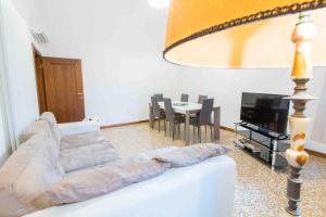 uma sala de estar com um sofá e uma mesa com cadeiras em CA CICOGNA air conditioning and fast WiFi, central location apartment em Veneza
