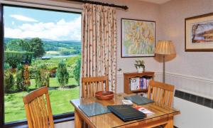una sala da pranzo con un tavolo e una grande finestra di Lakefield Cottage a Hawkshead