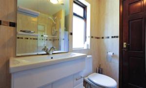 un bagno con lavandino, WC e finestra di Lakefield Cottage a Hawkshead