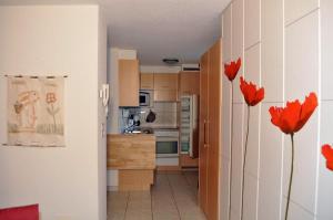 a kitchen with red flowers in a room at Heidi 16 in Bettmeralp
