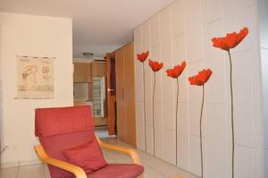 ベットマーアルプにあるHeidi 16の赤い椅子と赤い花が壁に飾られた部屋