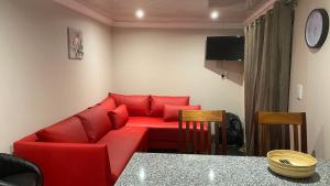 a living room with a red couch and a table at Guest House on Keam in East London