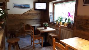 a restaurant with wooden tables and chairs and a window at Appartamenti Le Bistrot in Saint Nicolas