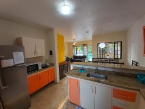 a kitchen with orange and white cabinets and a sink at Casa Canto Juqueí in Juquei