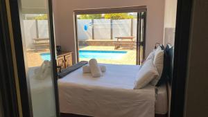 a bedroom with a bed with a view of a pool at Guest House on Keam in East London