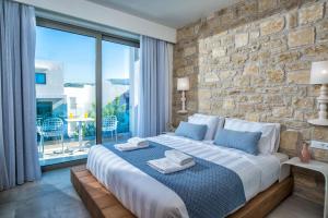 sypialnia z dużym łóżkiem i kamienną ścianą w obiekcie Mary Hotel & Mary Royal Suites w mieście Platanes