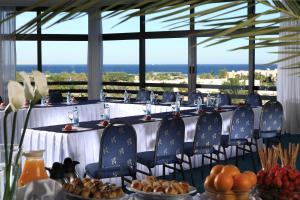 un groupe de longues tables avec des chaises bleues et de la nourriture dans l'établissement Pharaoh Azur Resort, à Hurghada