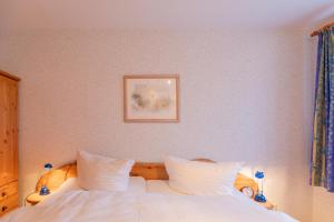 sypialnia z białym łóżkiem z obrazem na ścianie w obiekcie Maashof Theodor Storm w mieście Husum