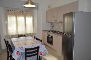 a kitchen with a table and a refrigerator at Casa Camilla in Marina di Castagneto Carducci