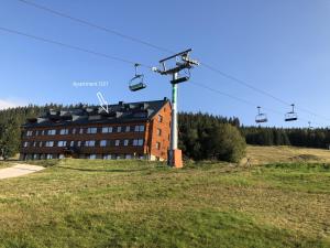 uma casa com um teleférico em frente a um edifício em Horní Mísečky Apartmán 021, up to 10 persons em Horni Misecky