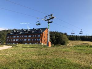 a house with a ski lift in front of a building at Horní Mísečky Apartmán 021, up to 10 persons in Horni Misecky