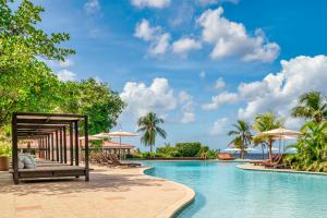 a pool at the resort with chairs and umbrellas at Dreams Curacao Resort, Spa & Casino in Willemstad