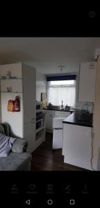 a kitchen with white cabinets and a counter top at 2 Bedroom Chalet near the Beach in Brading +2 photos