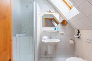 a white bathroom with a sink and a mirror at Maashof Nis Puck in Husum