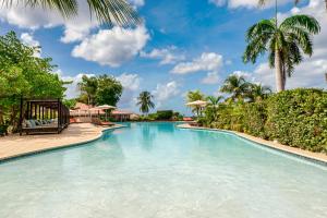 a swimming pool at a resort with palm trees at Dreams Curacao Resort, Spa & Casino in Willemstad