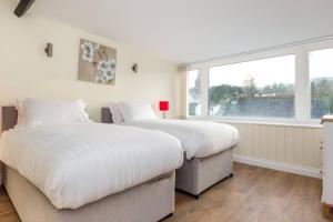 two beds in a bedroom with a large window at Lake Road Apartment Keswick in Keswick