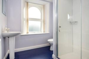 a bathroom with a toilet and a sink and a window at Lake Road Apartment Keswick in Keswick
