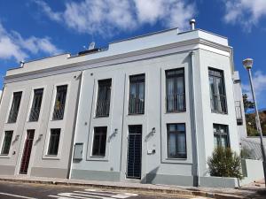 a white building on the side of a street at De Waterkant Cottages in Cape Town