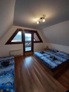 a bedroom with two beds and a large window at Andrea- neakceptujeme mladé partie in Terchová