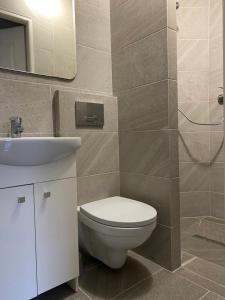 łazienka z toaletą, umywalką i lustrem w obiekcie Pokoje na wynajem Sopot w mieście Sopot