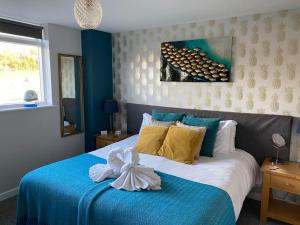 um quarto com uma cama azul e branca com um laço em The Riverside inn em Saltford