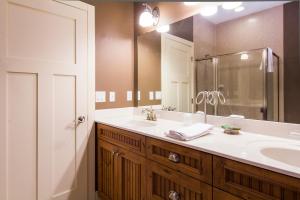 baño con lavabo y espejo grande en Larsmont Cottages, en Two Harbors