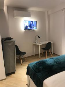 a bedroom with a bed and a tv on the wall at Hostal León in Torreorgaz