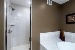 a bathroom with a shower and a toilet and a sink at Larsmont Cottages in Two Harbors