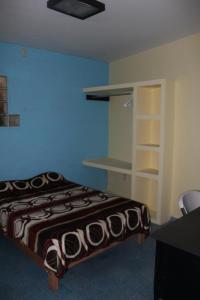 a bedroom with a bed and a desk and shelves at Posada de Vick in Orizaba