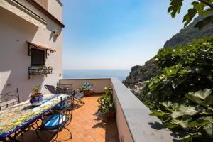 a balcony with a table and chairs overlooking the ocean at De Vivo Realty - Ilary House Positano in Positano