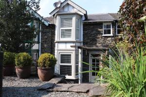 a house with potted plants in front of it at Pottery Gate, Bowness-on-Windermere in Bowness-on-Windermere