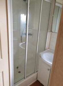 a bathroom with a shower and a toilet and a sink at Jasmine's Retreat - Pet friendly, Ingoldmells in Ingoldmells