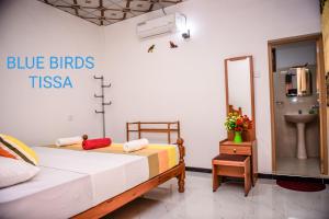 a bedroom with a blue birds tsa sign on the wall at Blue Birds Tissa & Yala safari in Tissamaharama