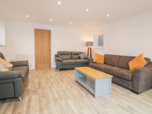 a living room with two couches and a coffee table at Lily Cottage in Camelford