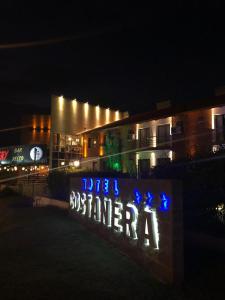 un edificio con un cartel que dice Bennett por la noche en Costanera Hotel en Villa Carlos Paz