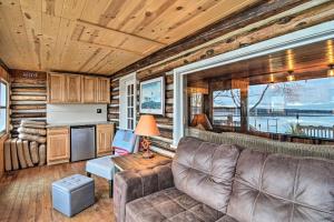 een woonkamer met een bank en een tafel bij Pickerel Lake Retreat with Grill, 15 Mi to Ski! in Petoskey