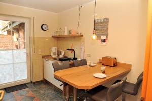 een keuken met een houten tafel met stoelen en een aanrecht bij Ferienwohnung bei Bunsel´s in Versmold