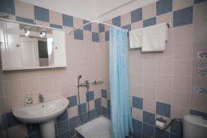 uma casa de banho com um lavatório, um chuveiro e um WC. em Nymphs Rooms & Apartments em Nikiana