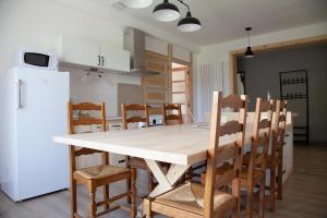 una cocina con una gran mesa de madera y sillas en La Châtelaine en La Rixouse