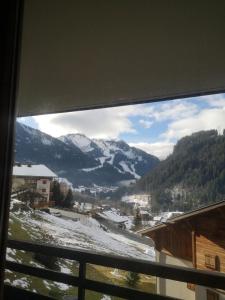 a view of a snow covered mountain from a window at Val Pierre in Châtel +2 photos