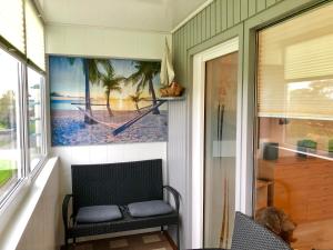 a porch with a bench and a picture of a boat at Ferienwohnung 258 Haus Schleswig in Kalifornien
