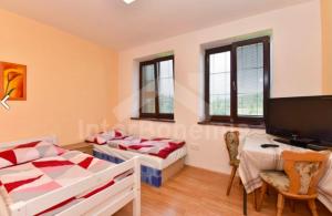 a living room with two beds and a desk at penzion Za lávkami in Dačice