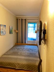 1 dormitorio con 1 cama, TV y ventana en Ferienwohnung 258 Haus Schleswig en Kalifornien