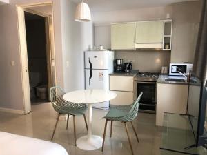 a kitchen with a table and chairs and a refrigerator at City Park Buenos Aires in Buenos Aires