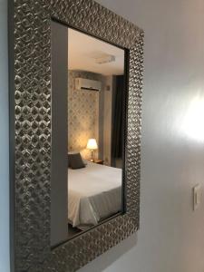 a mirror on a wall with a bed in a room at City Park Buenos Aires in Buenos Aires +60 photos