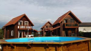 un groupe de maisons avec une piscine en face d'elles dans l'établissement Ferienhäuser Aura, à Sankt Andrä bei Frauenkirchen